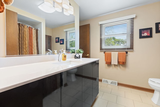 bathroom with toilet, baseboards, vanity, and tile patterned floors