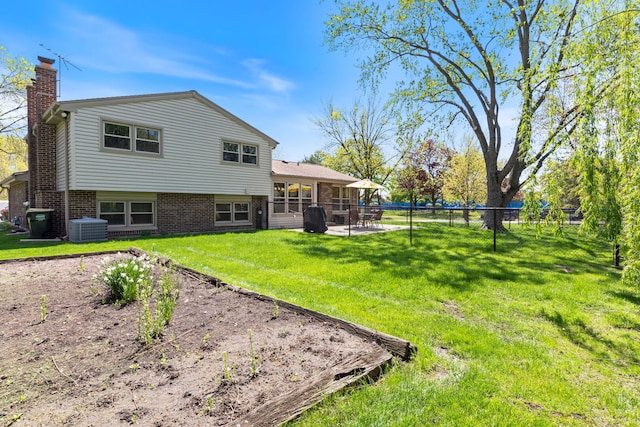 back of property with a chimney, central air condition unit, a patio area, and brick siding