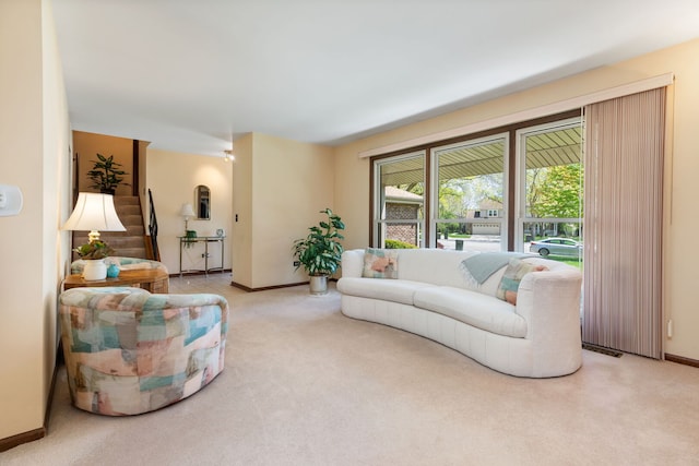 carpeted living area featuring baseboards