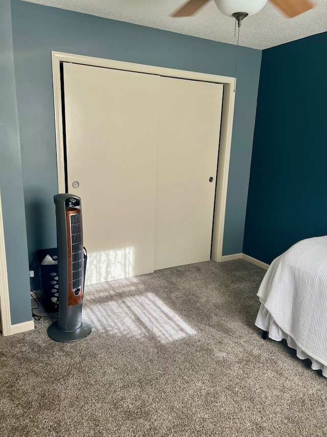 bedroom featuring carpet floors, ceiling fan, baseboards, and a closet