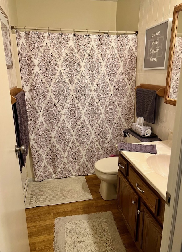 bathroom with vanity, toilet, wood finished floors, and a shower with shower curtain