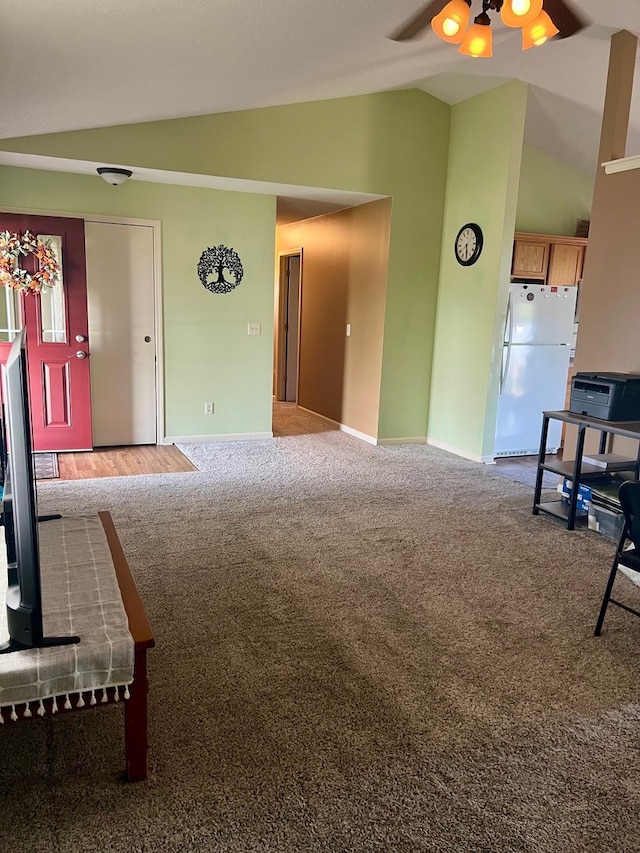 unfurnished living room with baseboards, ceiling fan, carpet flooring, and lofted ceiling