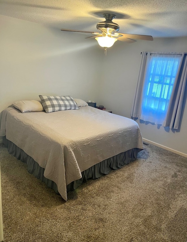 bedroom with baseboards, a ceiling fan, carpet, and a textured ceiling