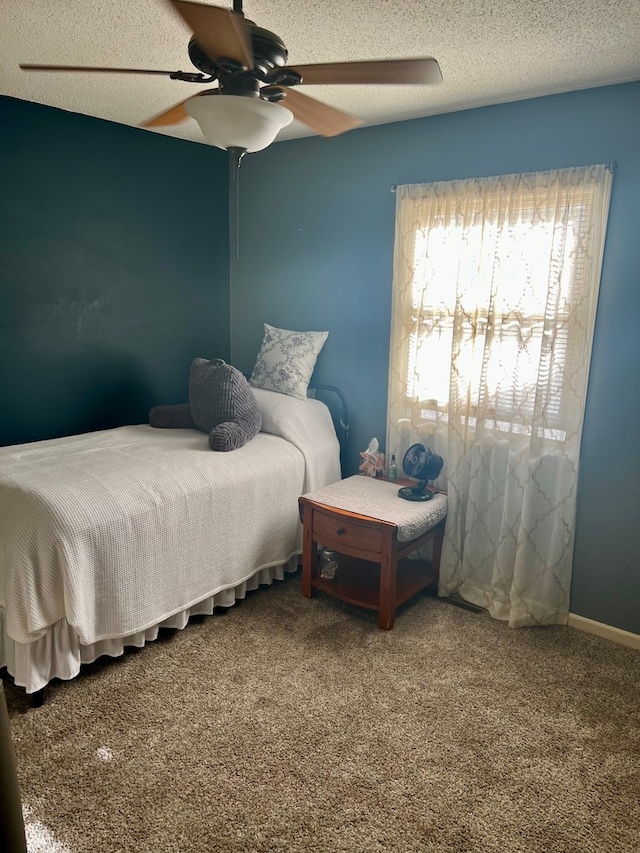 bedroom featuring carpet flooring, a ceiling fan, and a textured ceiling