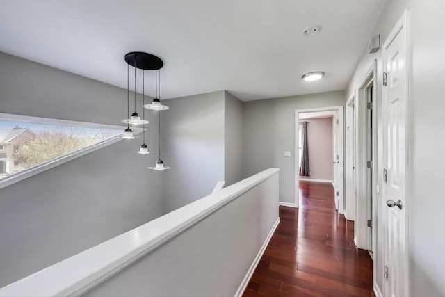 hallway featuring an upstairs landing, dark wood-style flooring, and baseboards