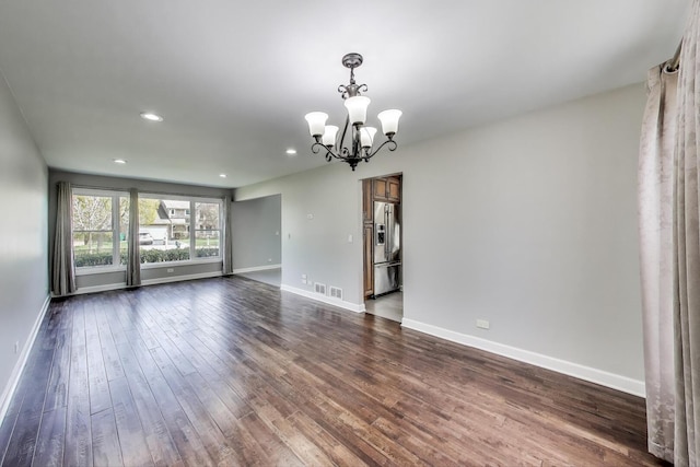 unfurnished room with a chandelier, dark wood-type flooring, baseboards, and recessed lighting