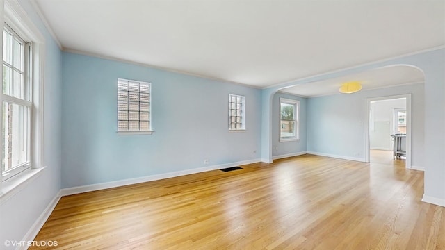 1730 Madison St, Evanston, IL 60202 - empty room featuring arched walkways, ornamental molding, baseboards, and light wood-style floors