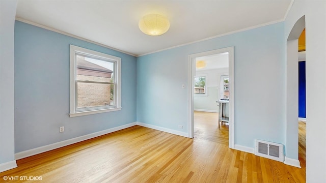 1730 Madison St, Evanston, IL 60202 - spare room featuring arched walkways, crown molding, baseboards, and light wood-style floors