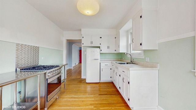 1730 Madison St, Evanston, IL 60202 - kitchen with stainless steel range with gas cooktop, a sink, freestanding refrigerator, light wood-style flooring, and light countertops