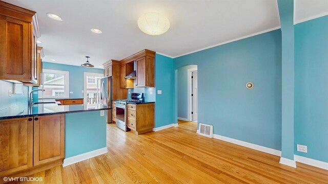 1730 Madison St, Evanston, IL 60202 - kitchen featuring appliances with stainless steel finishes, dark countertops, arched walkways, baseboards, and crown molding