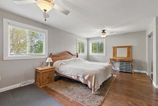 bedroom with visible vents, a ceiling fan, dark wood finished floors, and baseboards