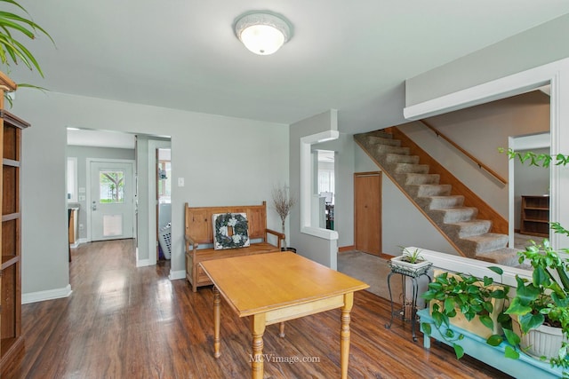 living room featuring stairway, baseboards, and wood finished floors