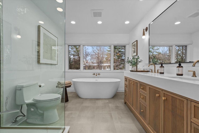 full bath featuring vanity, visible vents, toilet, recessed lighting, and a soaking tub