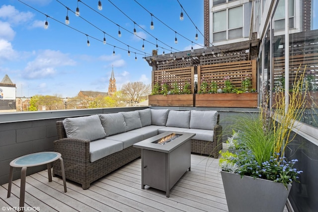 wooden terrace with an outdoor living space with a fire pit
