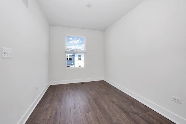 empty room with baseboards and dark wood-style flooring