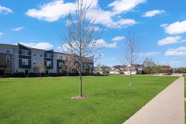 view of property's community with a residential view and a lawn