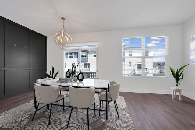 dining space with an inviting chandelier, baseboards, and dark wood-style floors
