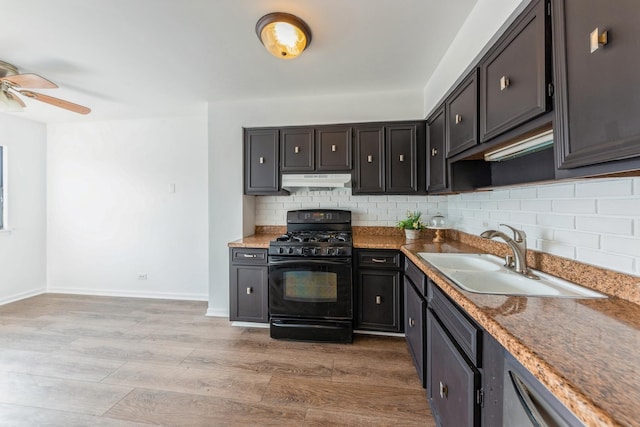 kitchen featuring tasteful backsplash, a sink, black range with gas stovetop, light wood finished floors, and under cabinet range hood