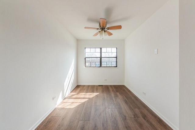 unfurnished room featuring baseboards, ceiling fan, and wood finished floors
