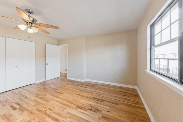 unfurnished bedroom with baseboards, ceiling fan, light wood-style flooring, and a closet