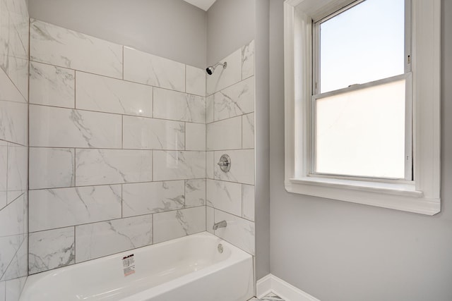 full bath featuring shower / bath combination, plenty of natural light, and baseboards