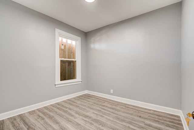 empty room with baseboards and light wood-style flooring