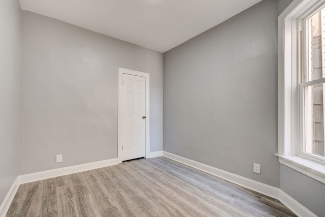 unfurnished room with baseboards and wood finished floors