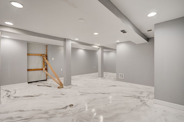 finished below grade area featuring visible vents, marble finish floor, baseboards, and recessed lighting