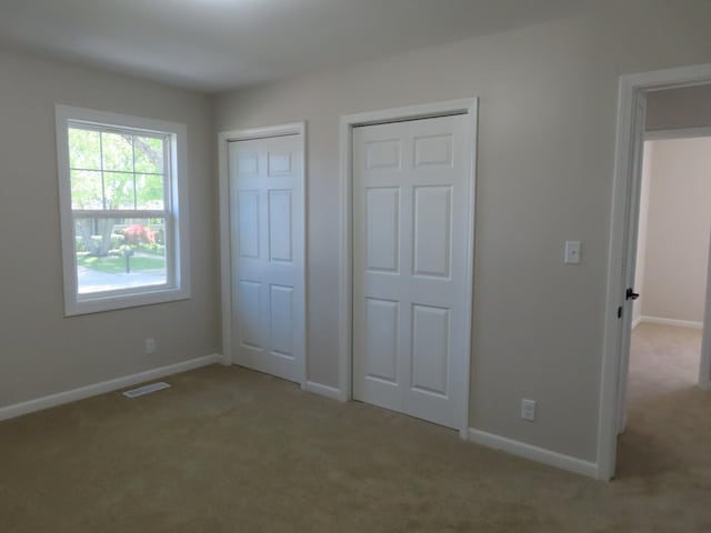 302 Windsor Dr, Ottawa, IL 61350 - unfurnished bedroom with carpet, two closets, and baseboards