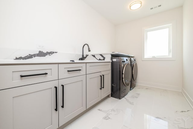 washroom with visible vents, marble finish floor, washer and clothes dryer, a sink, and cabinet space