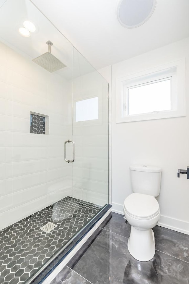 full bath featuring toilet, baseboards, and a stall shower