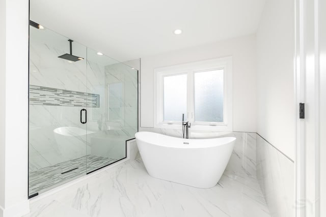 bathroom with a marble finish shower, a soaking tub, wainscoting, and marble finish floor