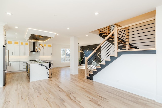kitchen featuring light wood-style floors, high end refrigerator, and a kitchen bar
