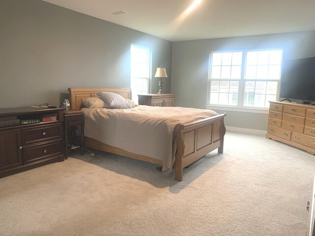 bedroom featuring baseboards and light carpet