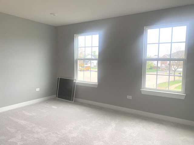 unfurnished room with baseboards and light colored carpet