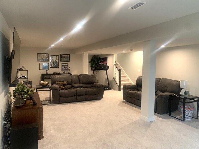 living area with visible vents, light carpet, and stairway