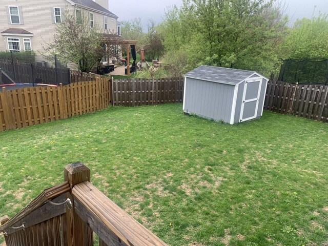 view of yard featuring a storage shed, a pergola, an outdoor structure, and a fenced backyard