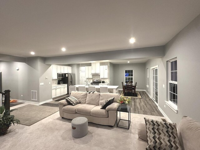 living room featuring baseboards, recessed lighting, wood finished floors, and visible vents