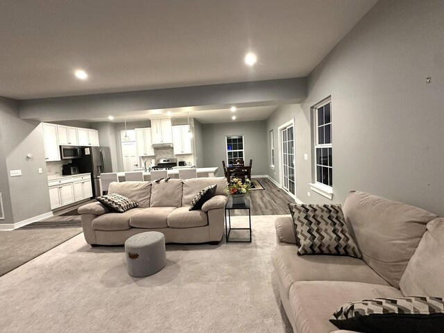 living room with baseboards, recessed lighting, and wood finished floors