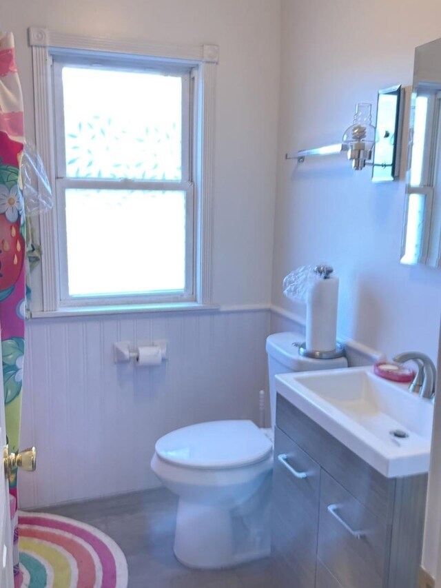 10455 S Forest Ave, Chicago, IL 60628 - full bathroom with vanity, toilet, a shower with shower curtain, and a wainscoted wall
