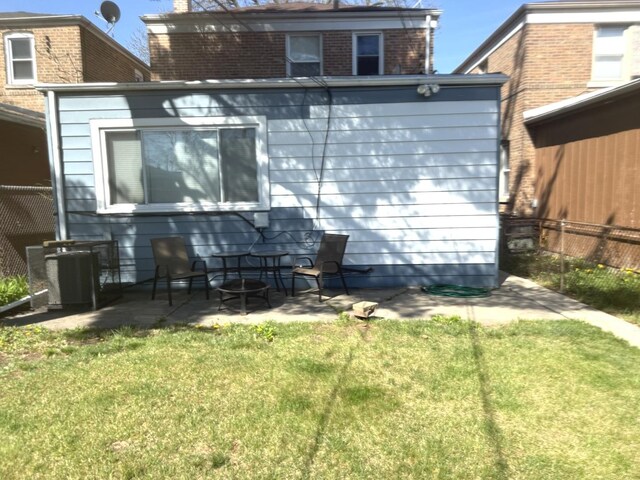 10455 S Forest Ave, Chicago, IL 60628 - rear view of property with a lawn, central AC unit, a patio area, brick siding, and fence