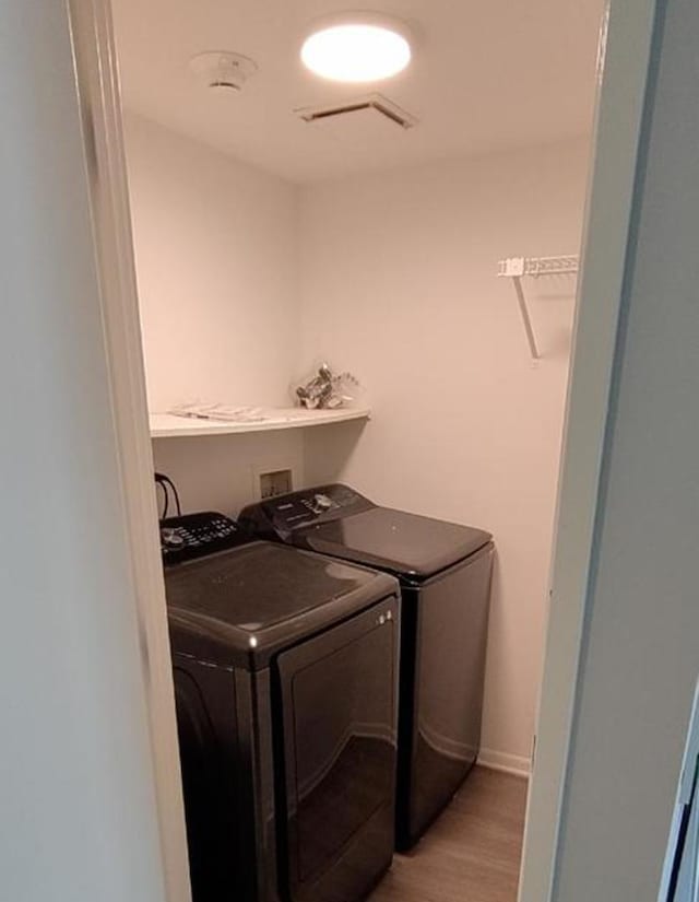 55 W 64th St Unit 202, Westmont, IL 60559 - laundry area with laundry area, light wood-style floors, visible vents, and washing machine and clothes dryer