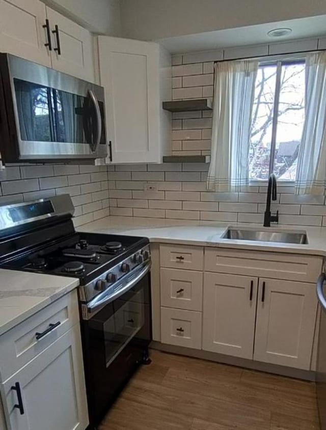 55 W 64th St Unit 202, Westmont, IL 60559 - kitchen featuring white cabinets, open shelves, a sink, gas stove, and stainless steel microwave