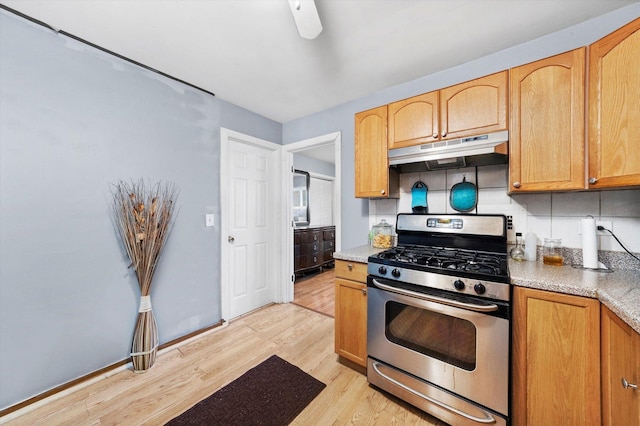 165 Dover Dr Unit 3, Des Plaines, IL 60018 - kitchen with stainless steel gas stove, light wood-type flooring, light countertops, under cabinet range hood, and backsplash
