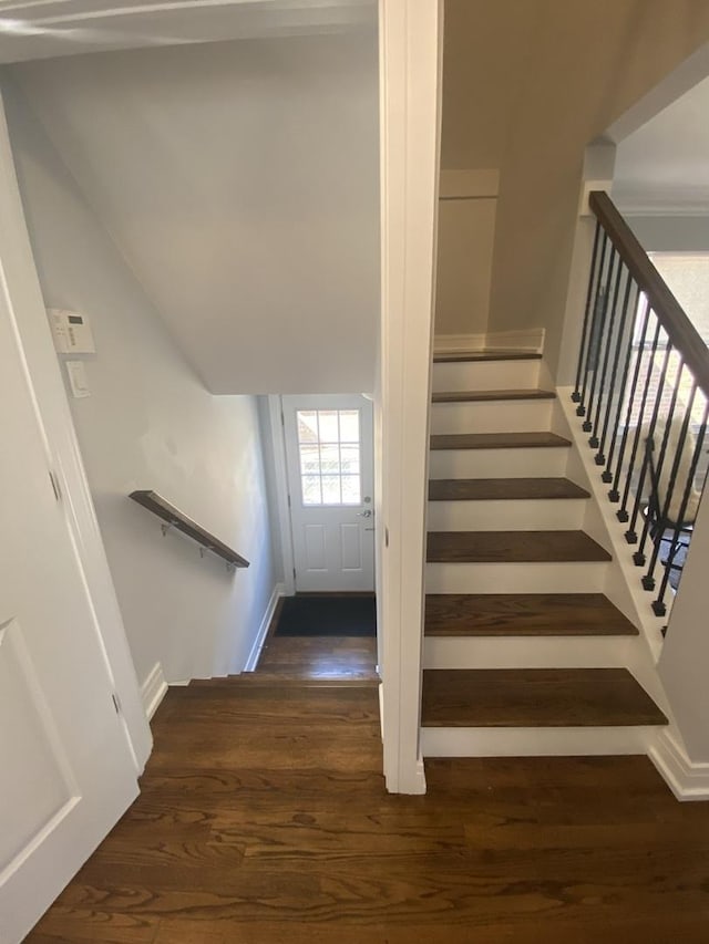staircase featuring baseboards and wood finished floors