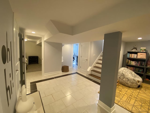 finished below grade area with recessed lighting, tile patterned floors, baseboards, and stairway