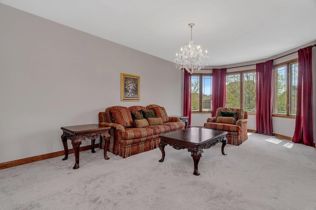 carpeted living area with baseboards and an inviting chandelier