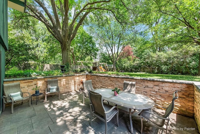 622 Katherine St, Saint Charles, IL 60174 - fenced backyard featuring a patio, outdoor dining area, view of wooded area, and a playground
