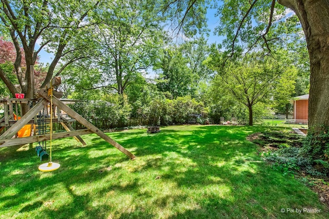 622 Katherine St, Saint Charles, IL 60174 - fenced backyard featuring a playground, a fire pit, and view of scattered trees