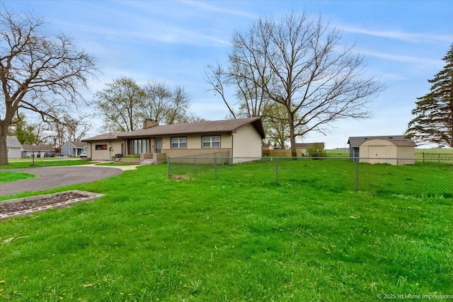 view of front of home with a chimney, a front yard, fence, aphalt driveway, and an attached garage